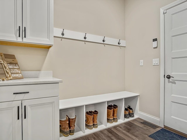 mudroom featuring baseboards, visible vents, and wood finished floors