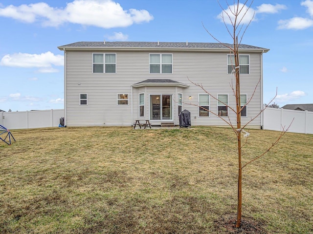 back of house featuring a fenced backyard and a lawn