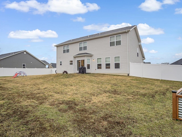 back of house featuring a fenced backyard and a lawn