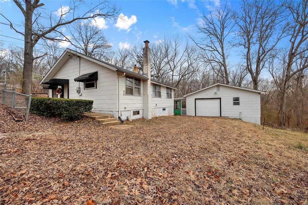 view of home's exterior featuring a garage and an outbuilding