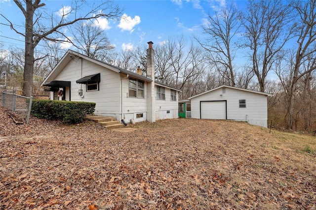 view of home's exterior featuring a garage and an outbuilding