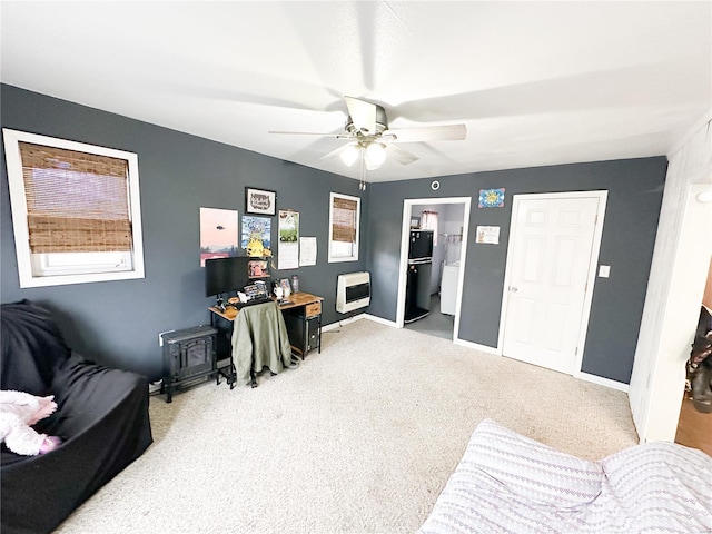 carpeted office space with heating unit and ceiling fan