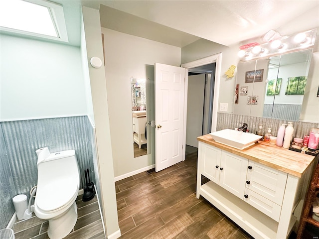 bathroom with hardwood / wood-style flooring, vanity, and toilet