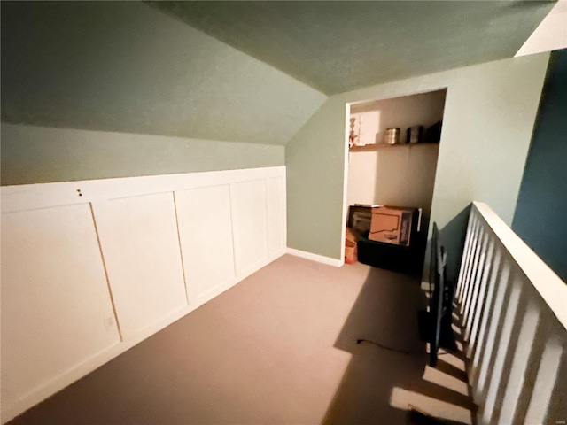 additional living space featuring lofted ceiling and light carpet