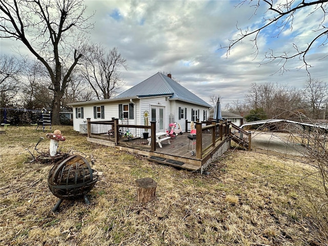 back of house with a wooden deck, french doors, and an outdoor fire pit