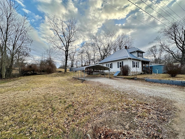 view of side of property with a carport and a lawn