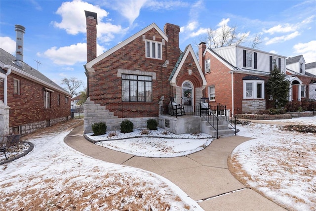 view of front of house featuring brick siding and a chimney