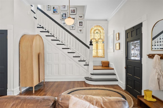 foyer entrance with crown molding and dark hardwood / wood-style floors