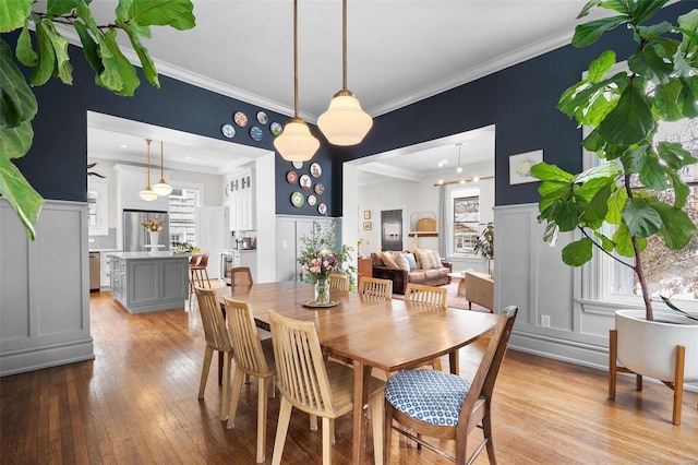 dining room featuring light hardwood / wood-style floors, plenty of natural light, and ornamental molding