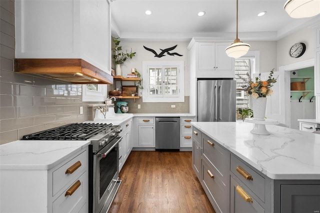 kitchen featuring white cabinets, high end appliances, gray cabinets, and decorative light fixtures