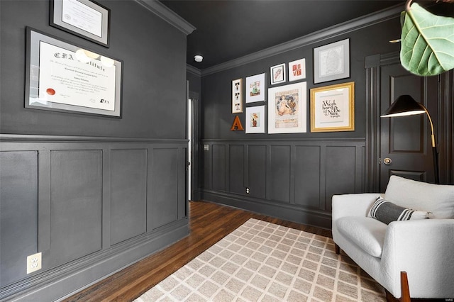 sitting room with crown molding and dark wood-type flooring