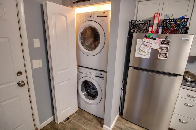 washroom featuring stacked washer / drying machine and light wood-type flooring