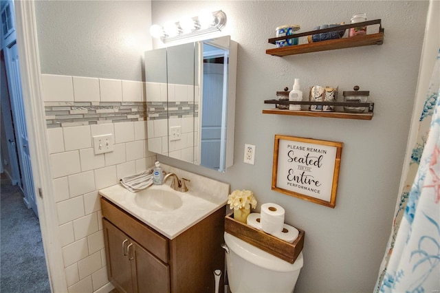 bathroom featuring vanity, toilet, and tile walls