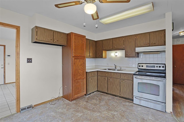 kitchen with sink, backsplash, stainless steel electric stove, and ceiling fan