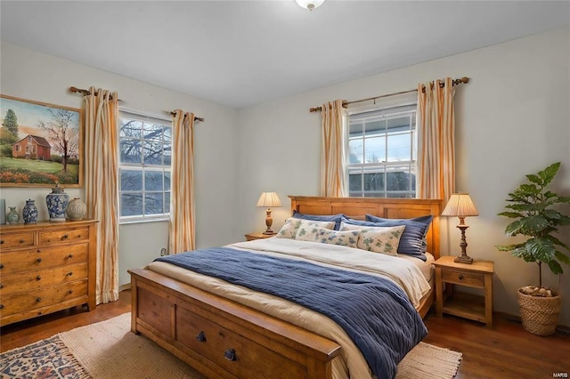 bedroom with dark hardwood / wood-style flooring and multiple windows