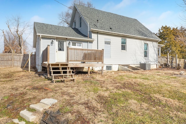 rear view of property featuring a wooden deck, a yard, and central AC