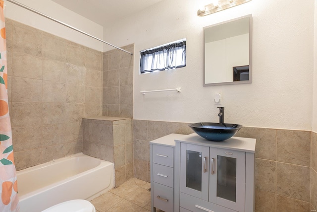 full bathroom with tile walls, tile patterned flooring, vanity, shower / tub combo, and toilet