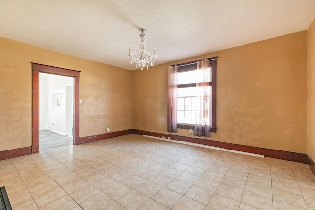 tiled empty room featuring a chandelier