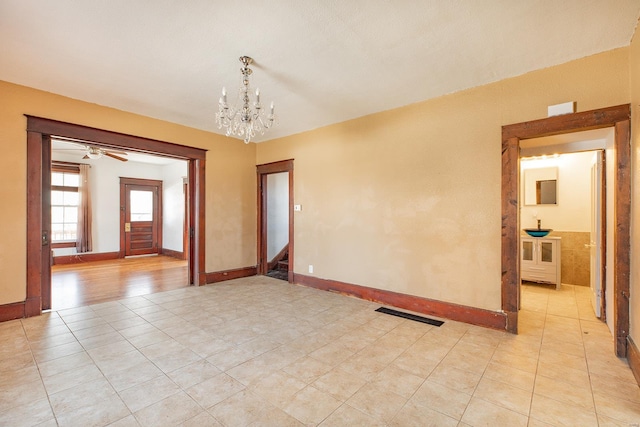 spare room featuring light tile patterned flooring and a chandelier