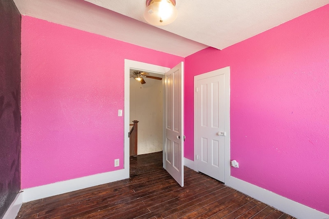 unfurnished bedroom with dark wood-type flooring