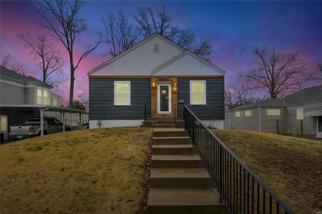 view of front of house with a yard and a carport