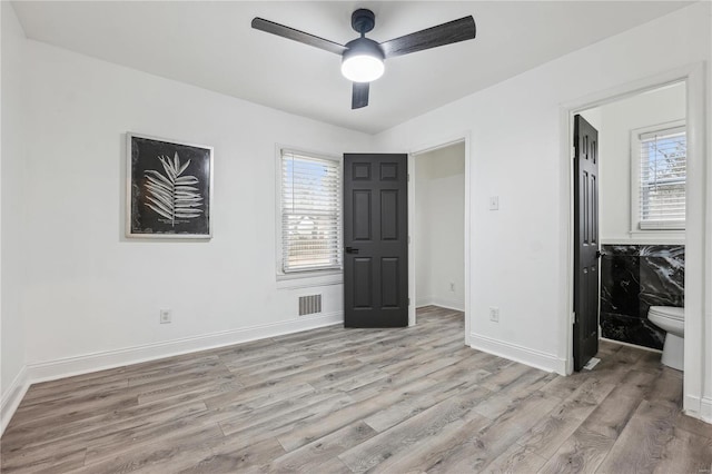 unfurnished bedroom featuring multiple windows, light hardwood / wood-style floors, and ceiling fan