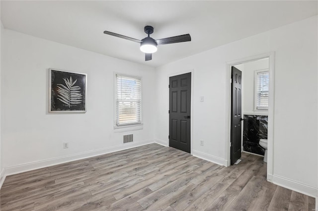 unfurnished bedroom featuring ceiling fan, light hardwood / wood-style floors, and multiple windows