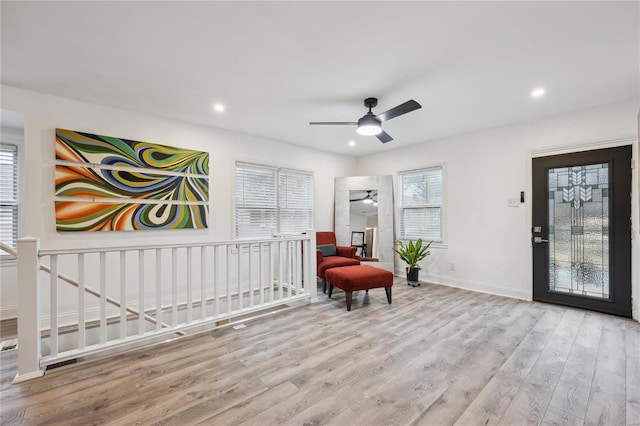 sitting room with ceiling fan and light wood-type flooring