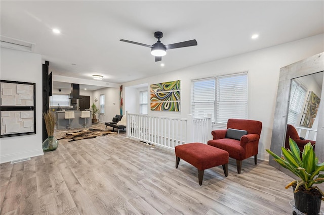 living area featuring ceiling fan and light hardwood / wood-style flooring