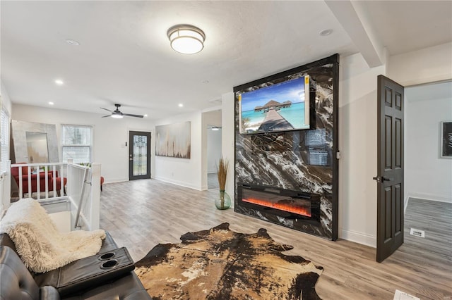 home theater featuring a large fireplace and light wood-type flooring