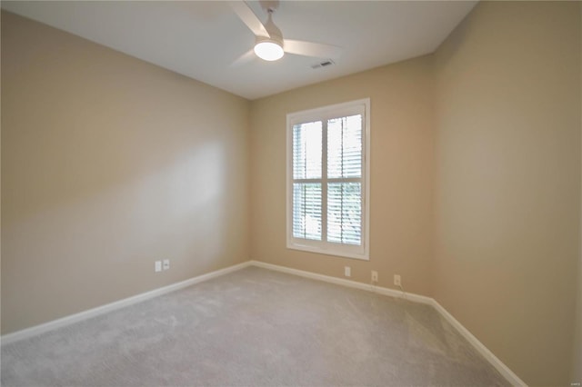 spare room featuring light colored carpet and ceiling fan