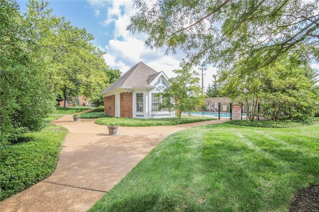 view of home's community with a swimming pool and a yard