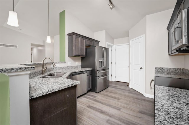 kitchen featuring stainless steel appliances, pendant lighting, a sink, and dark brown cabinets