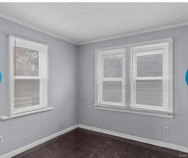 empty room featuring dark wood-type flooring and crown molding