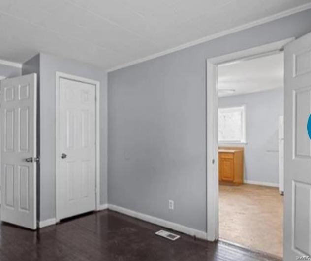 unfurnished bedroom featuring dark wood-type flooring and a closet