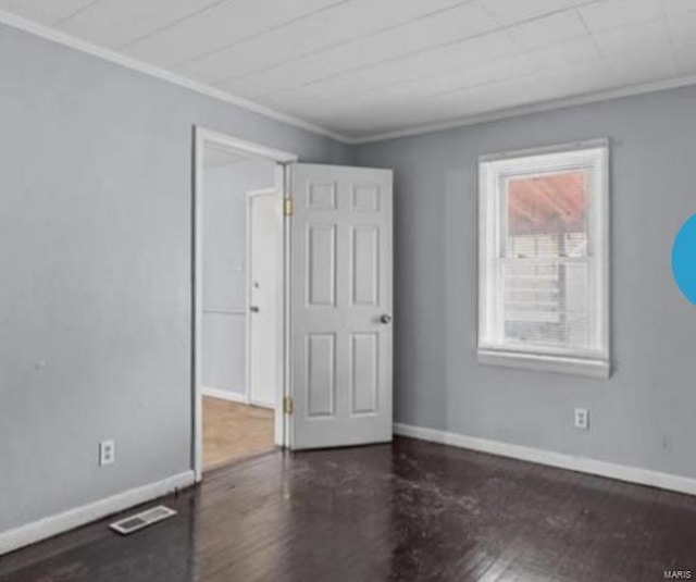 empty room with dark hardwood / wood-style flooring and crown molding