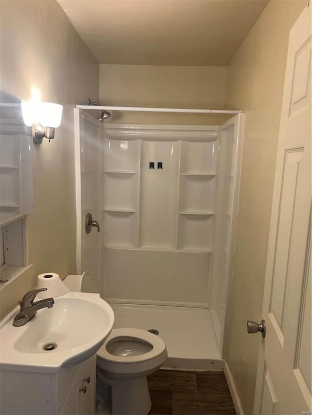 bathroom with vanity, toilet, hardwood / wood-style floors, and walk in shower