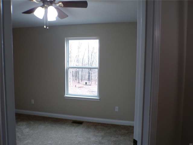 carpeted empty room featuring ceiling fan and a healthy amount of sunlight