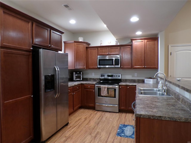 kitchen with sink, light wood-type flooring, and appliances with stainless steel finishes