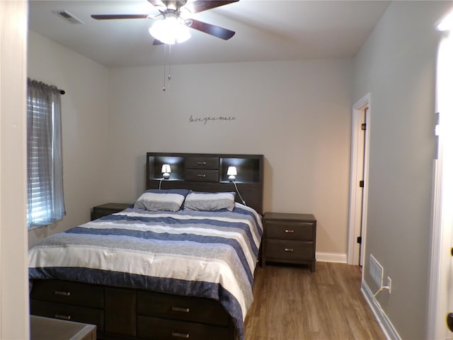 bedroom with baseboards, ceiling fan, visible vents, and light wood-style floors