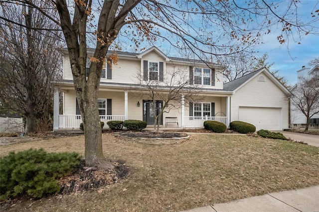 view of front of property featuring a garage, a front yard, and covered porch