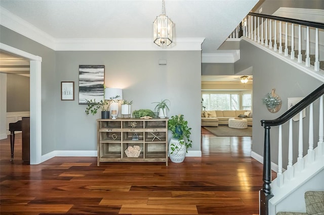 corridor with dark hardwood / wood-style flooring, crown molding, and a chandelier