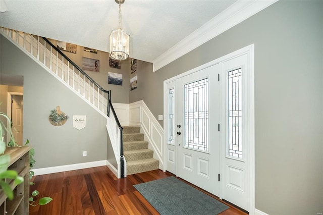 foyer featuring ornamental molding and dark hardwood / wood-style flooring