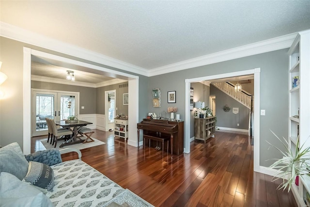 living room with french doors, ornamental molding, dark hardwood / wood-style floors, and a textured ceiling