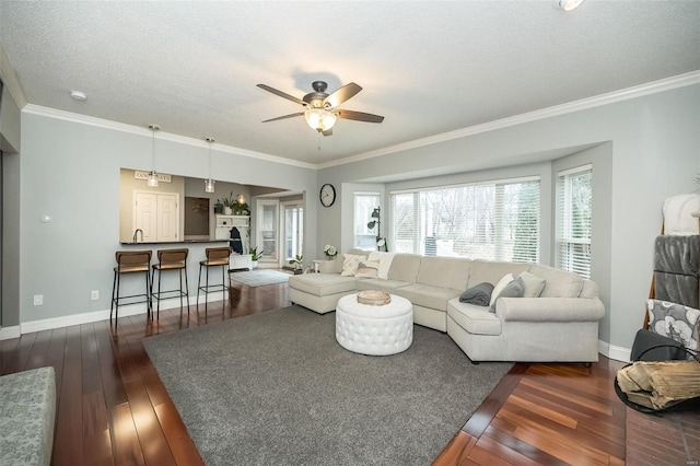 living room featuring ceiling fan, ornamental molding, dark hardwood / wood-style floors, and a textured ceiling