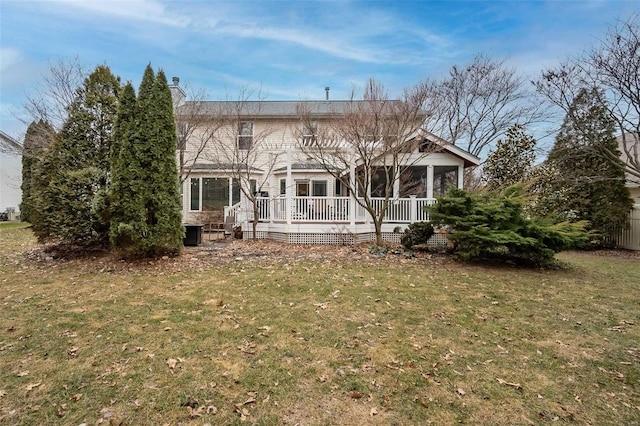 back of house featuring a wooden deck and a yard