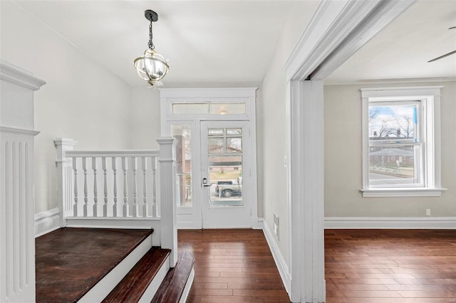 foyer entrance with dark hardwood / wood-style floors and a notable chandelier