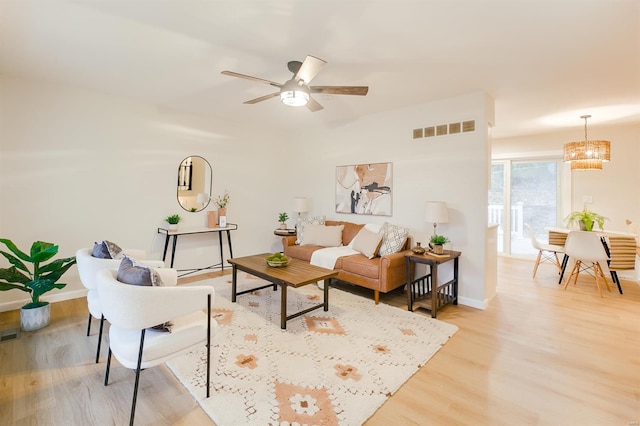 living room featuring ceiling fan and light hardwood / wood-style floors