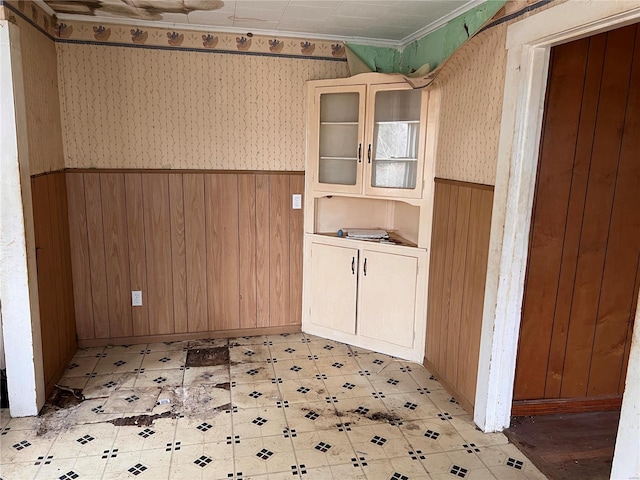 interior space with crown molding and wooden walls