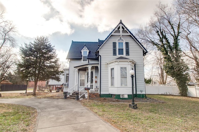 victorian house featuring cooling unit and a front lawn